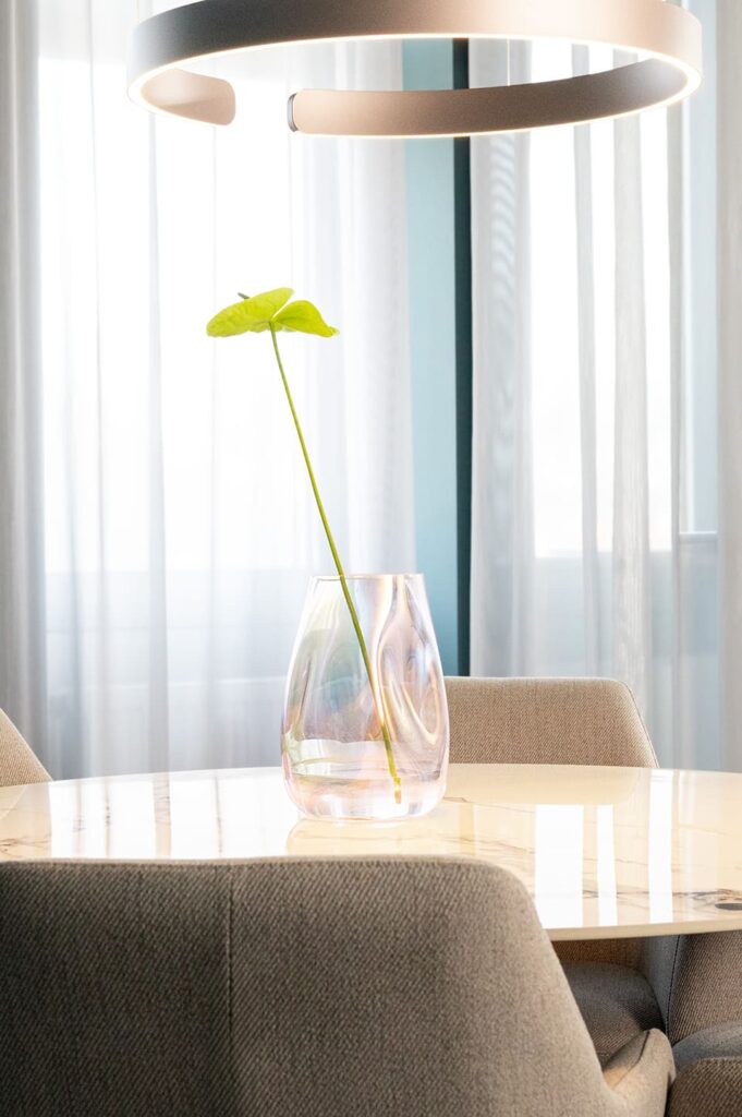Glasvase mit Pflanze auf einem hellem Tisch mit Stühlen in einem modernen Office Space Stuttgart