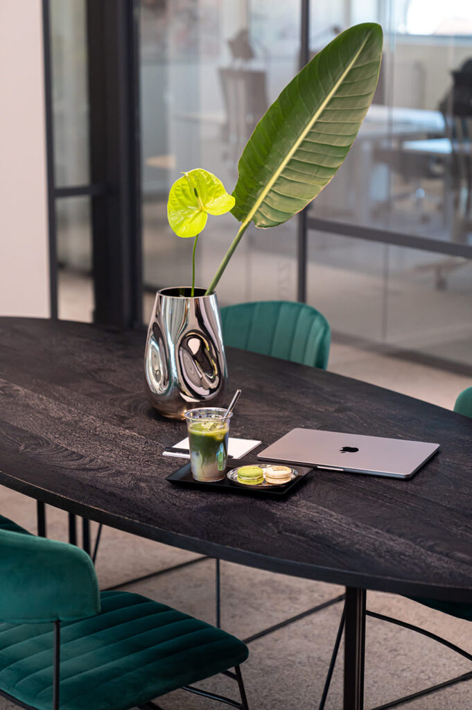 Meetingplatz mit Laptop, Notizblock und Matcha sowie Macarons mit Branding einer Online Marketing Agentur